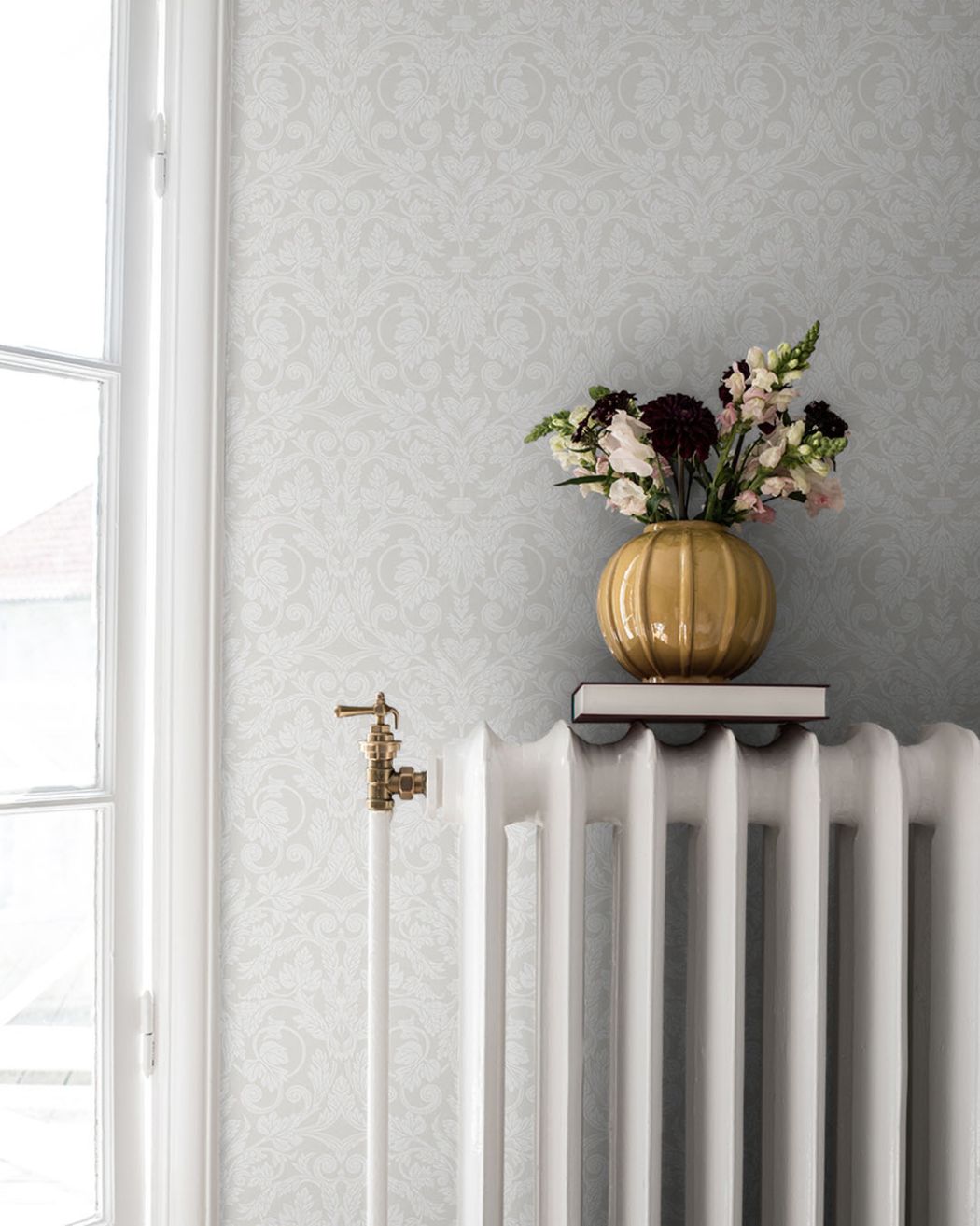 vit ton i ton tapet med vita fönsterlister och sekelskifts element