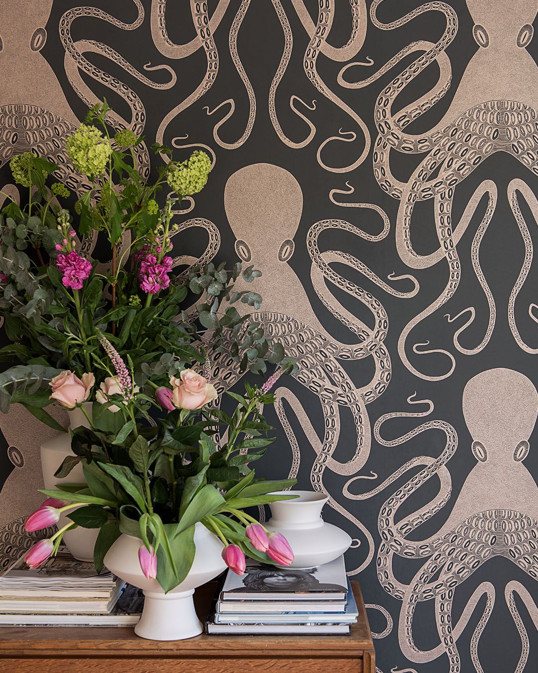 rum med svart tapet med stora bläckfiskar och färska blommor i vas